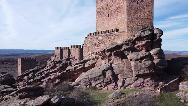 Raising drone view over Zafra Castle in Campillo de Duenas
in Spain with sea in the background