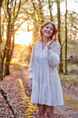 smiling girl in white dress in a forest