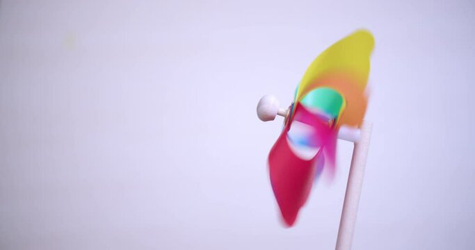 Kids toy plastic turbine. Colorful rainbow wind spiral. Plastic windmill rotates colored.