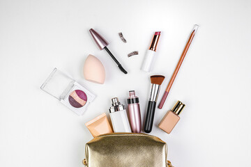 Golden cosmetic bag with makeup. Perfume, lip liner, lipstick, mascara, foundation. False...
