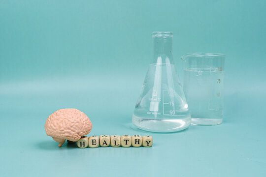 Brain on a blue background. lettering health. Place for text. White pills for memory. Chemical flasks. Drug laboratory.