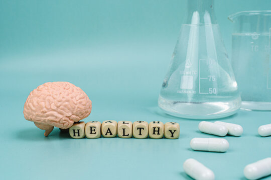 Brain on a blue background. lettering health. Place for text. White pills for memory. Chemical flasks. Drug laboratory.
