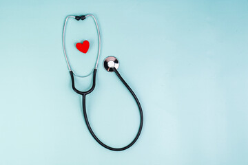 Phonendoscope and red heart on a blue background. The concept of a healthy heart, good health. Red heart and stethoscope. Cardiology, heart health and care, Health Day concept. cardiovascular disease