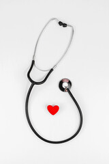 Phonendoscope and red heart on a white background. The concept of a healthy heart, good health. Red heart and stethoscope. Cardiology, heart health and care, Health Day concept. Copy space.