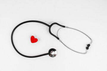 Phonendoscope and red heart on a white background. The concept of a healthy heart, good health. Red heart and stethoscope. Cardiology, heart health and care, Health Day concept. Copy space.