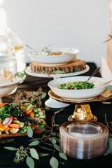 Holiday table with salads and dishes on a black tablecloth