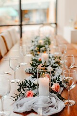 Vertical shot of a table with candles and bouquets prepared for the wedding ceremony