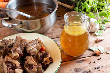 Homemade Beef Bone Broth in glass on wooden table. Bones contain collagen, which provides the body with amino acids, which are the building blocks of proteins