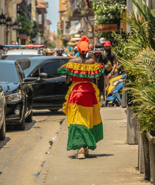 Colombian woman with typical dress of Cartagena de Indias walking through the streets. Travel photography. Trip to Colombia. Woman talking with her smartphone