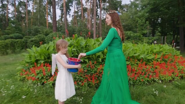 Fairy fairy and baby angel in the park with brushes for paint.