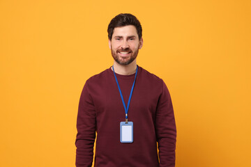 Smiling man with VIP pass badge on orange background