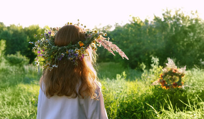 Girl in flower wreath on meadow, sunny green abstract natural background. Floral crown, symbol of Midsummer, summer solstice. ritual ceremony for wiccan Litha sabbat. pagan holiday Ivan Kupala.  - obrazy, fototapety, plakaty