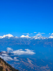 Amazing view of the snow capped mountains of the Himalayan range from kalinchowk province of Nepal with the hills and clouds around.