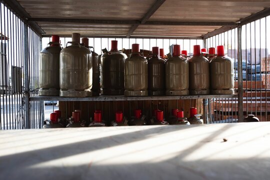 several empty tanks sit on a metal rack in a garage