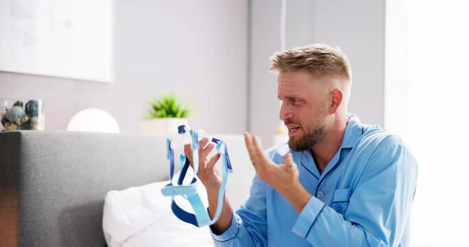 Shocked Young Man Holding CPAP Machine