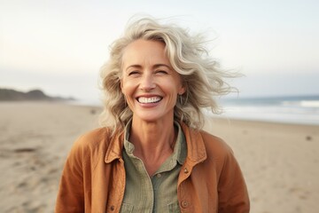 AI generated image of happy mature woman at the beach - obrazy, fototapety, plakaty