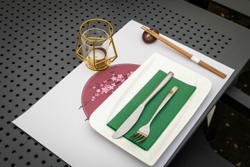 Table layout with chopsticks, a knife, a fork and a decorative candle at a local Japanese restaurant