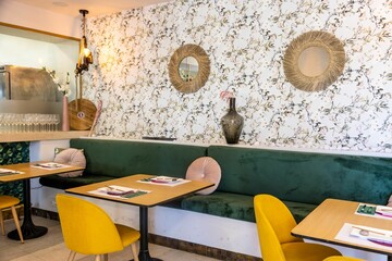 Cozy interior at a local cafe with a comfortable green sofa and flower-printed walls