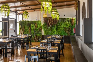 Scenic view of the interior of a beautifully decorated restaurant with vegetation and leaves © Damián Méndez/Wirestock Creators