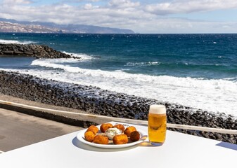 Obraz premium Glass of beer and snacks Socorro en Guimar beach in Tenerife