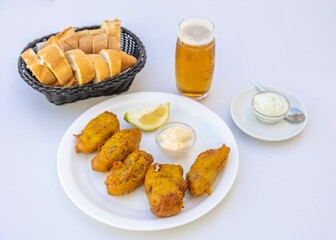 Close-up shot of chicken nuggets with a sauce and beer on a table