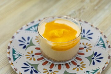 Close-up shot of sweet Panna Cotta in colorful plate on a wooden table
