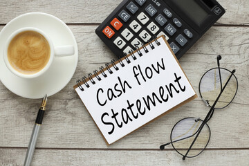 cash flow statement. top view of notepad with text and calculator. cup of coffee on the work table