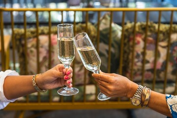 Female hands raising toasts with champagne