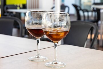 Closeup of two glasses of dark brown drinks on the table