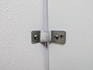 Closeup of Fixing metal bracket on white wall of a public toilet