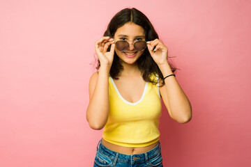 Adorable teenager putting on summer sunglasses