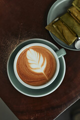 Selective focus cup of hot latte art coffee on wooden table