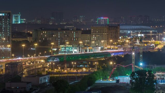 Moscow timelapse panorama, night aerial top view of the third transport ring and the central part of Moscow's rings, traffic, car lights from rooftop. Luzhniki stadium on background