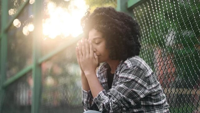 Portrait of sad young African American girl suffering from depression anxiety loneliness or mental problem while someone offers her helping hand outdoors Faith and support concept