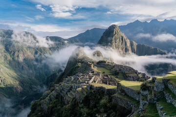 machu picchu in the morning with clounds and fog
