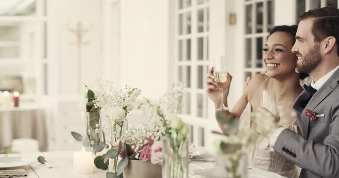 Wedding, reception and champagne to toast and celebrate bride, groom and marriage at a dining table. Man and woman with friends at a table with wine glass for cheers, celebration and party together
