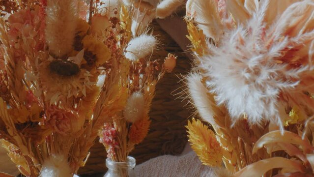 Forward slide showing decorative dried flowers in vases. Closeup dolly