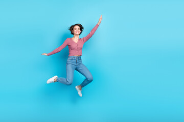 Fototapeta na wymiar Full size portrait of overjoyed pretty girl jumping have good mood empty space isolated on blue color background