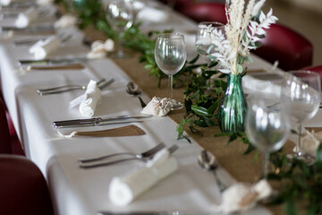 Une table de mariage moderne avec des décorations, des couverts, des fleurs séchés et de napperons blanc - obrazy, fototapety, plakaty