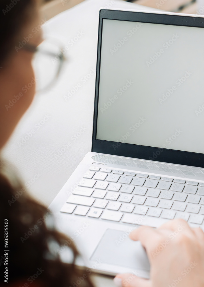 Wall mural over shoulder view of woman student elearning looking at white mock up blank screen using laptop com