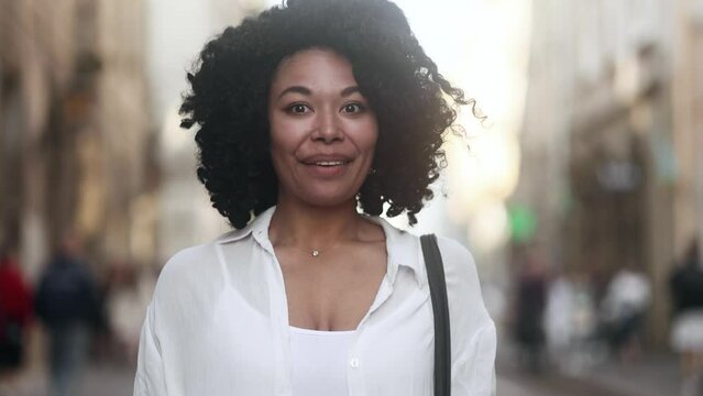 Pretty young curly african american woman thinks questioningly finding solution and show smartphone with green screen chroma key advertising template for your design at city screen Like Recommendation
