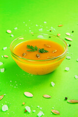 Autumn Vegetarian pumpkin and carrot cream soup on Vibrant emerald backdrop