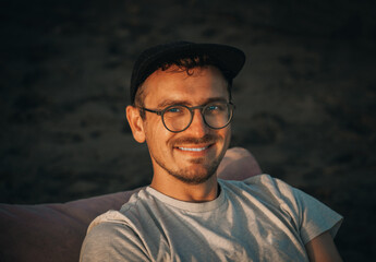 Young 32 years old Caucasian man traveler tourist with basecap on sandy beach on sand dune....