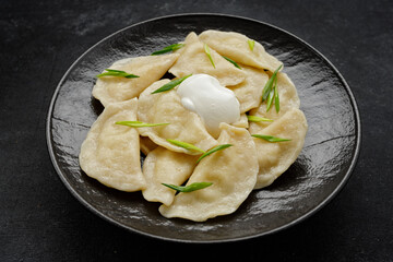 ukrainian dumplings with potatoes, sour cream, and green onions