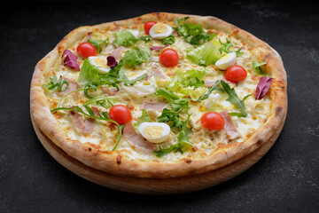 pizza with meat. tomatoes, quail eggs, and herbs. deluxe pizza