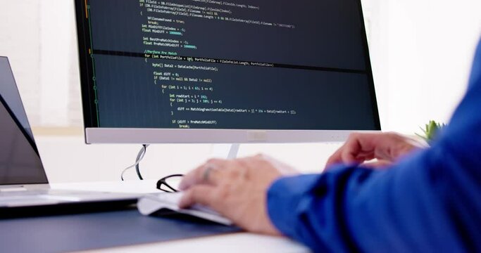 Computer Programmer Writing Program Code On Computer