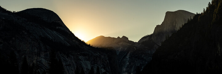 Silhouettes Of North Dome And Half Dome As Sun Rises Over The Ridge Behind Them