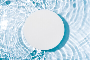 Round white podium for cosmetics on the water surface. Top view.