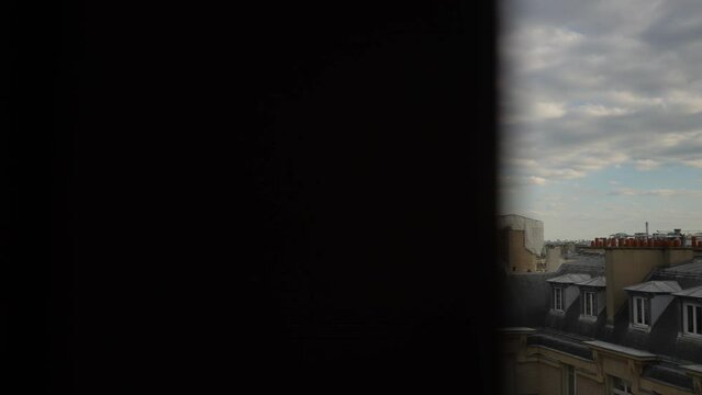 Tracking shot of Eiffel Tower from apartment window on cloudy day in dark room. Peaceful morning view of iconic Eiffel Tower in Paris through open hotel window, slow motion. Travel and romance concept