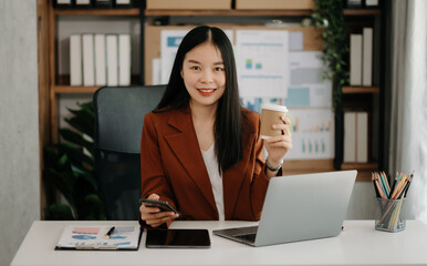 Asian businesswoman working in the office with working notepad, tablet and laptop documents in office.